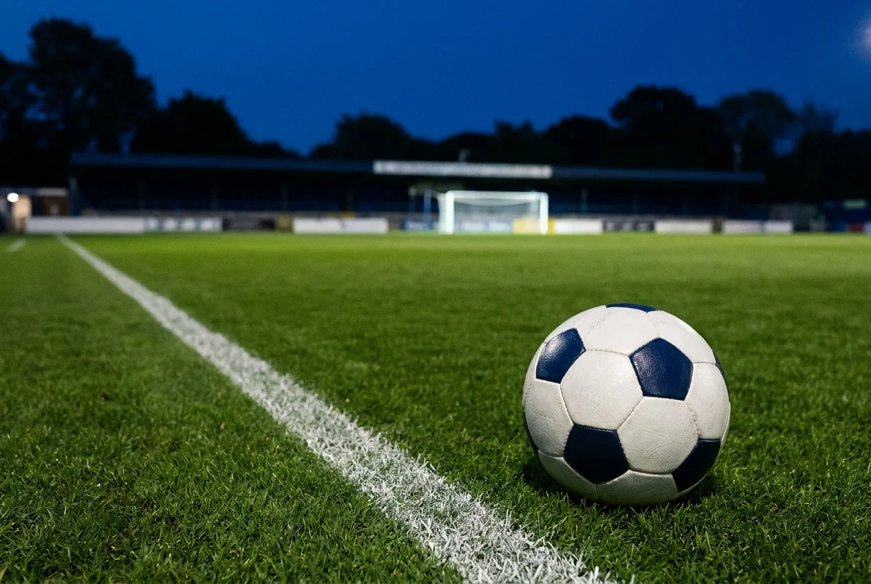 A football beside a white touchline on an imagined ground at blue hour